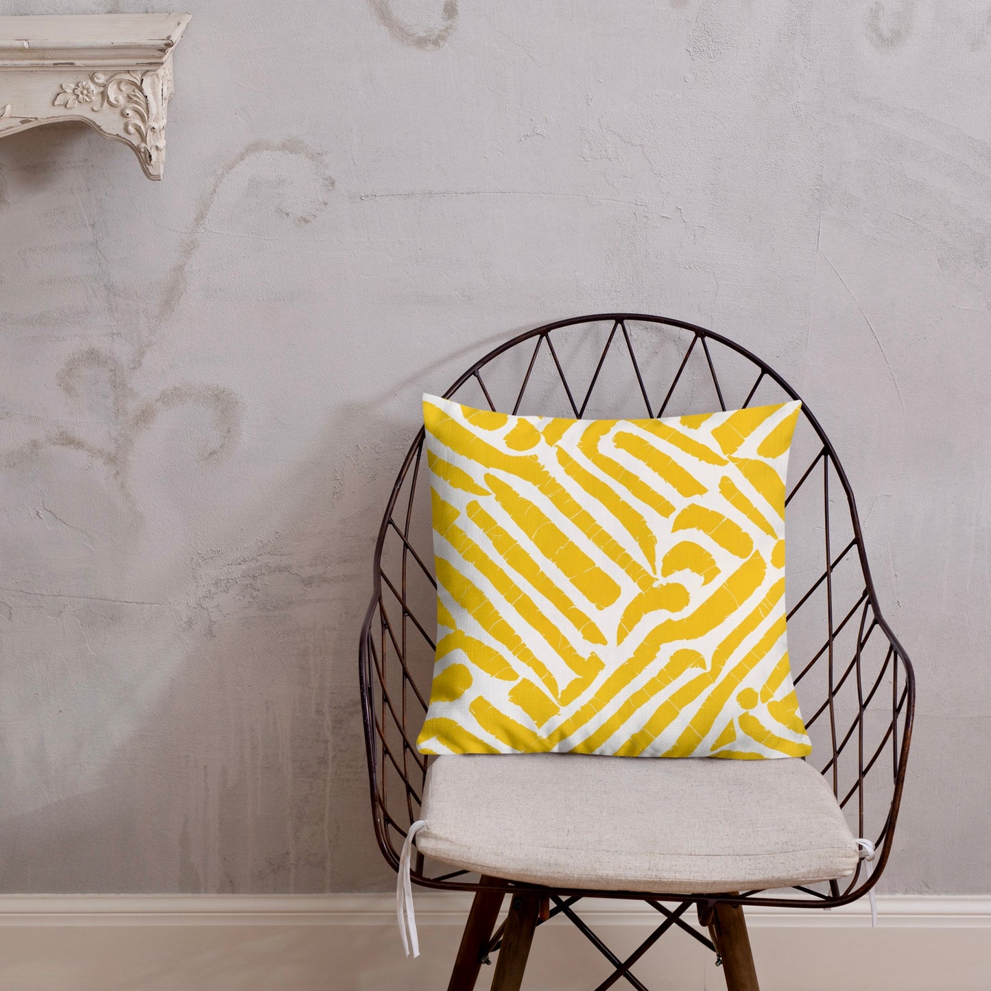 18x18 ChiChi yellow throw pillow from Tintin Studios, bright and decorative on a black iron chair.