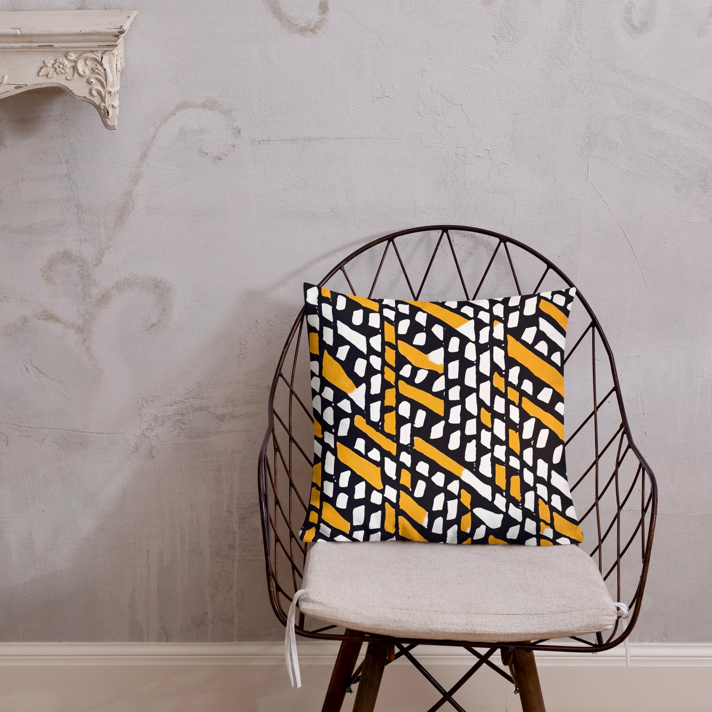 18x18 Ilorin orange throw pillow from Tintin Studios, vibrant and rustic on a black iron chair.