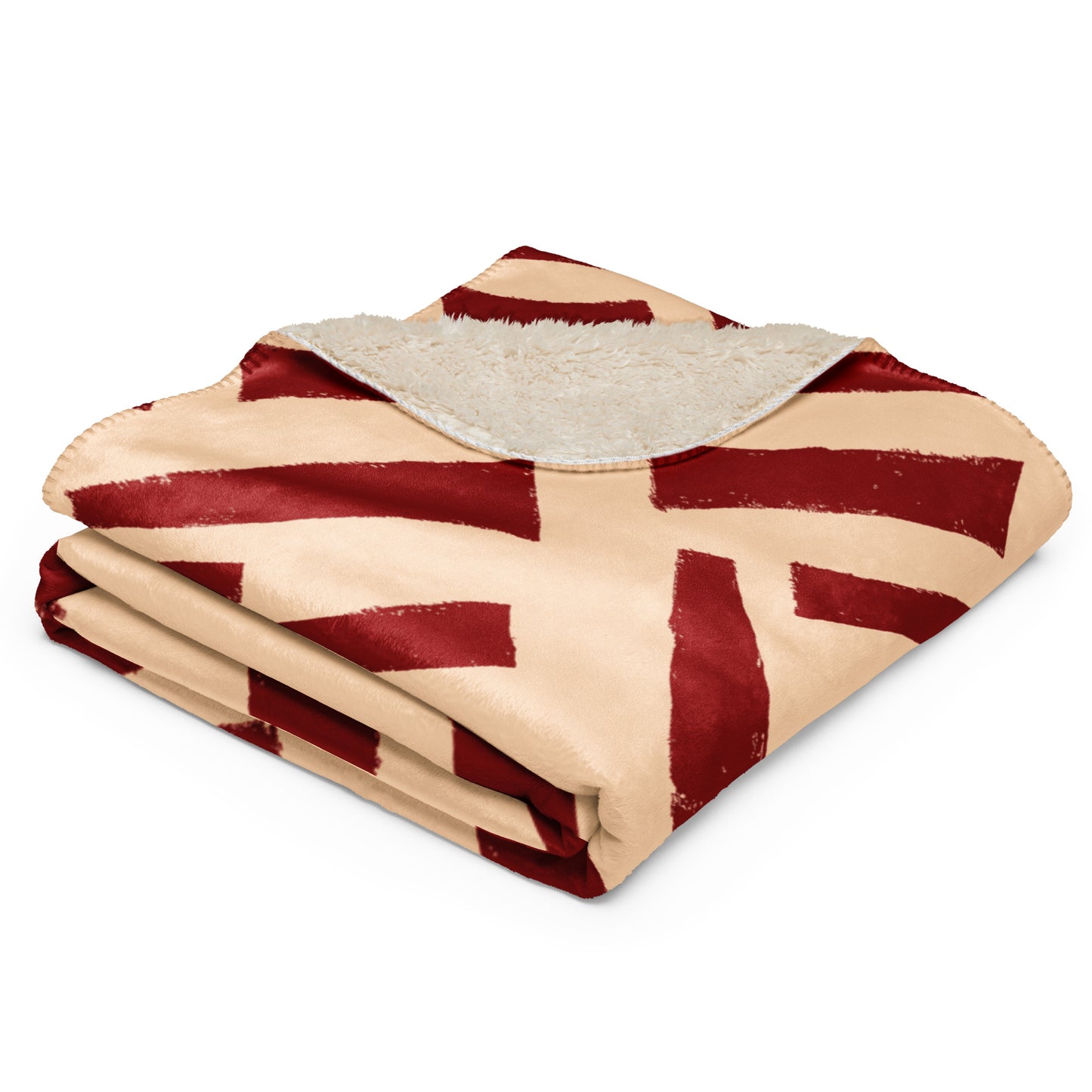 The red Tutu Sherpa blanket from Tintin Studios folded neatly to display its unique abstract patterns and luxurious sherpa underside, offering a glimpse of its artful allure and plush comfort.