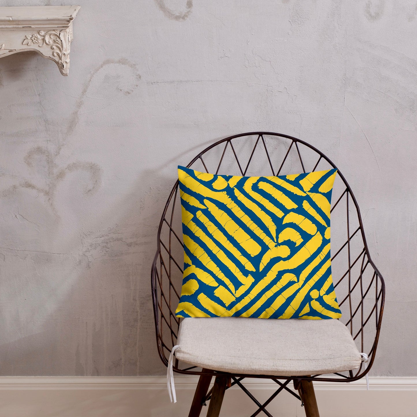 18x18 ChiChi blue throw pillow from Tintin Studios, showcasing elegant patterns on a black iron chair.