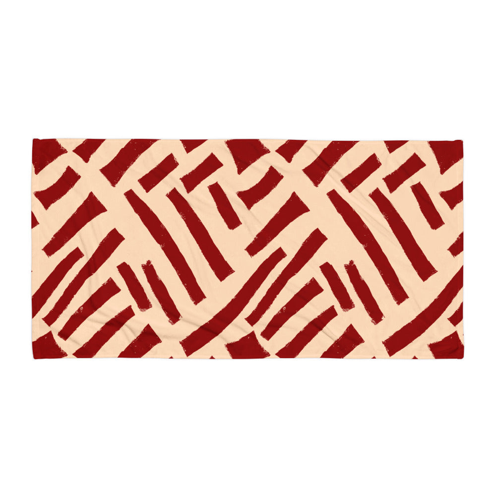 Striking red Tutu beach towel from Tintin Studios laid out flat on a white background, emphasizing its bold and energetic abstract patterns