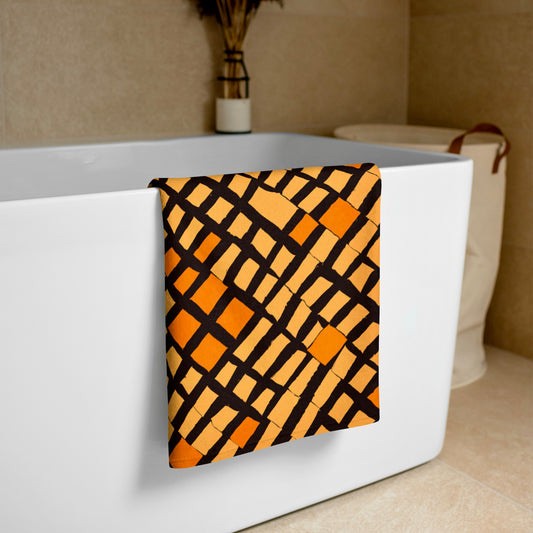 Tintin Studios' orange Lagos beach towel gracefully draped over a white bathtub, showcasing its sleek design and luxurious feel, perfect for sophisticated tastes.