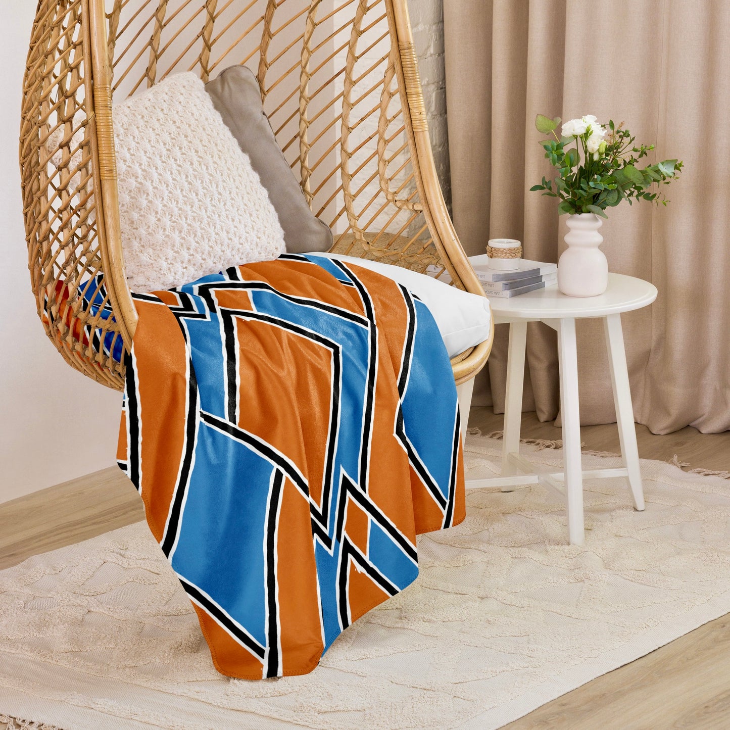 Brown Nana Sherpa blanket from Tintin Studios gracefully hanging on a wicker chair, integrating a calm blue hue into a serene reading nook.