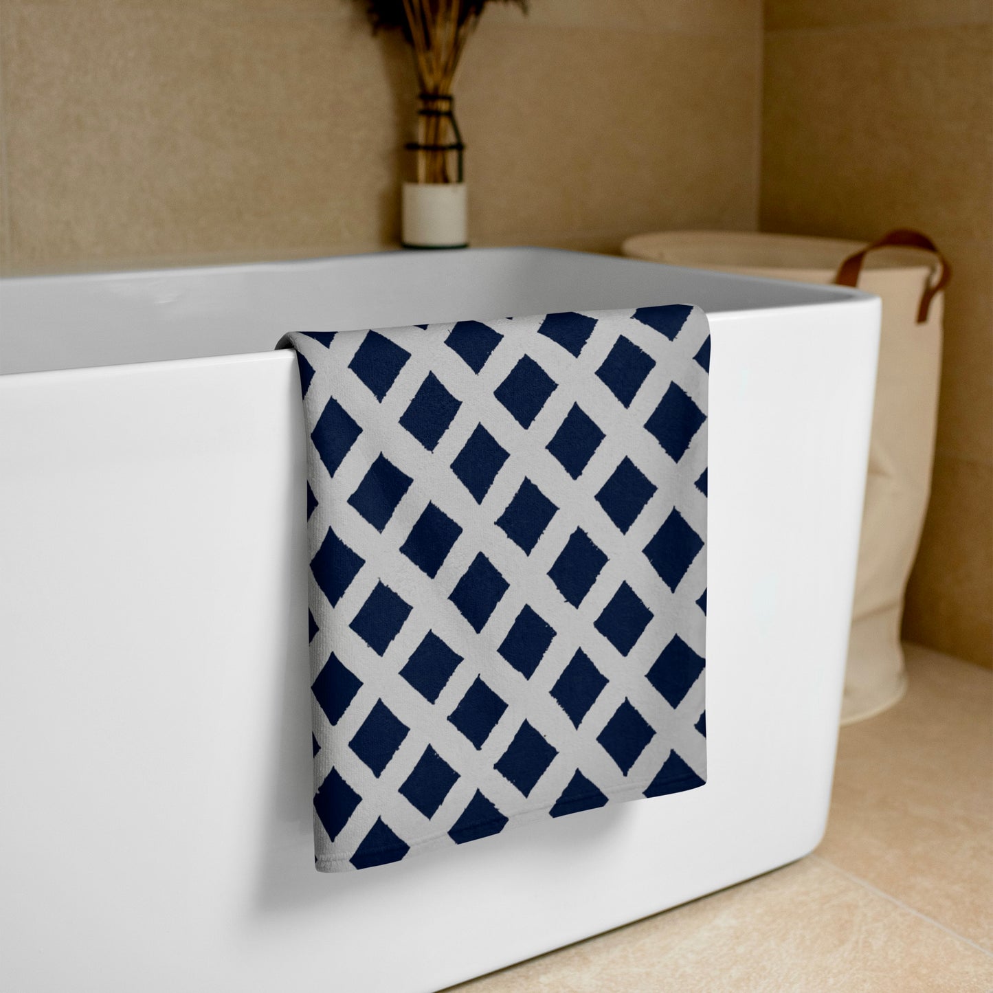 Softly folded blue Zaria towel from Tintin Studios resting on a white bathtub, highlighting its elegant simplicity and supreme comfort.