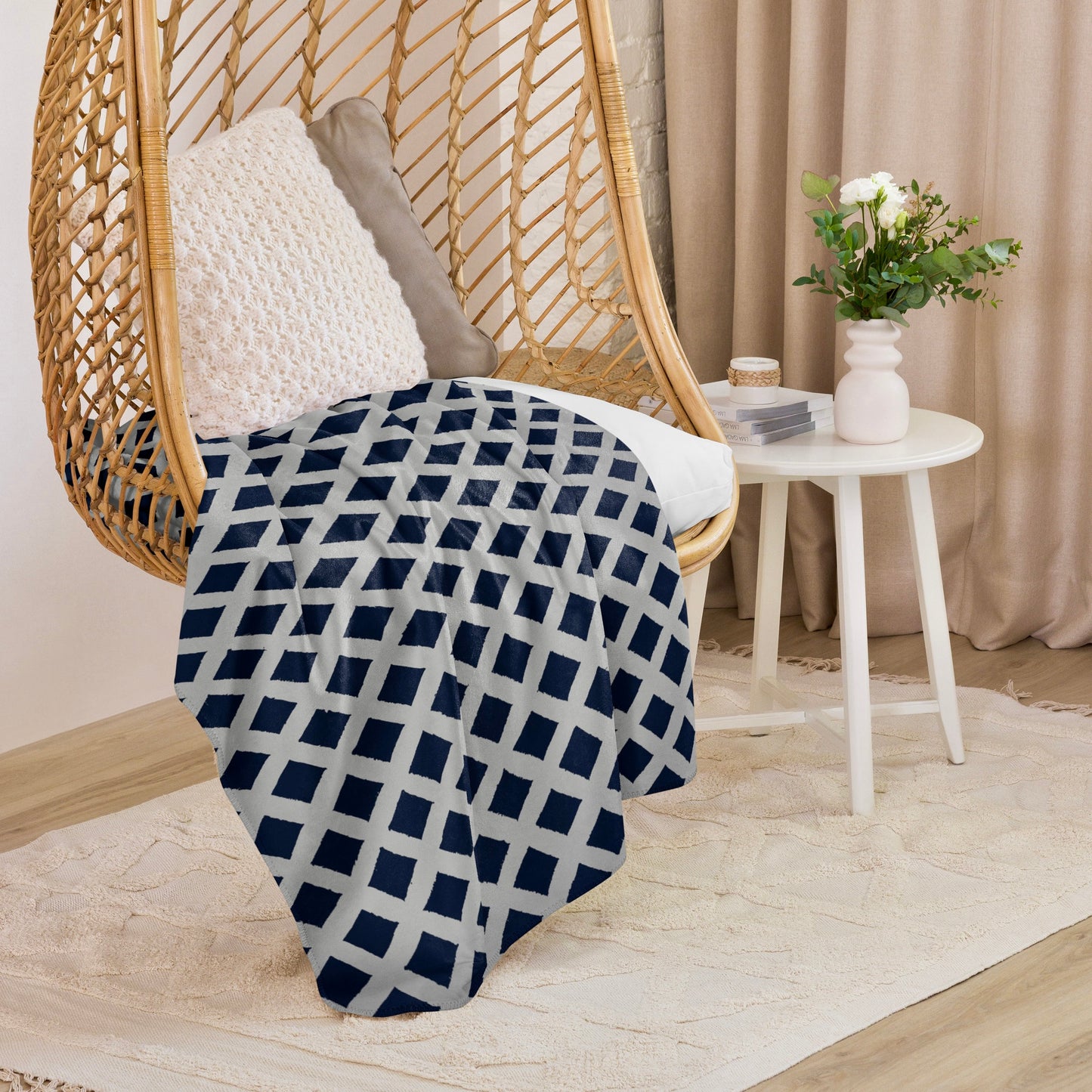 Blue Zaria Sherpa blanket from Tintin Studios hanging on a wicker chair, with serene patterns ideal for adding a calming touch to any room.