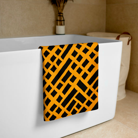 Orange Felele beach towel from Tintin Studios elegantly draped over a white bathtub, emphasizing its vivid cultural motifs and luxurious feel.