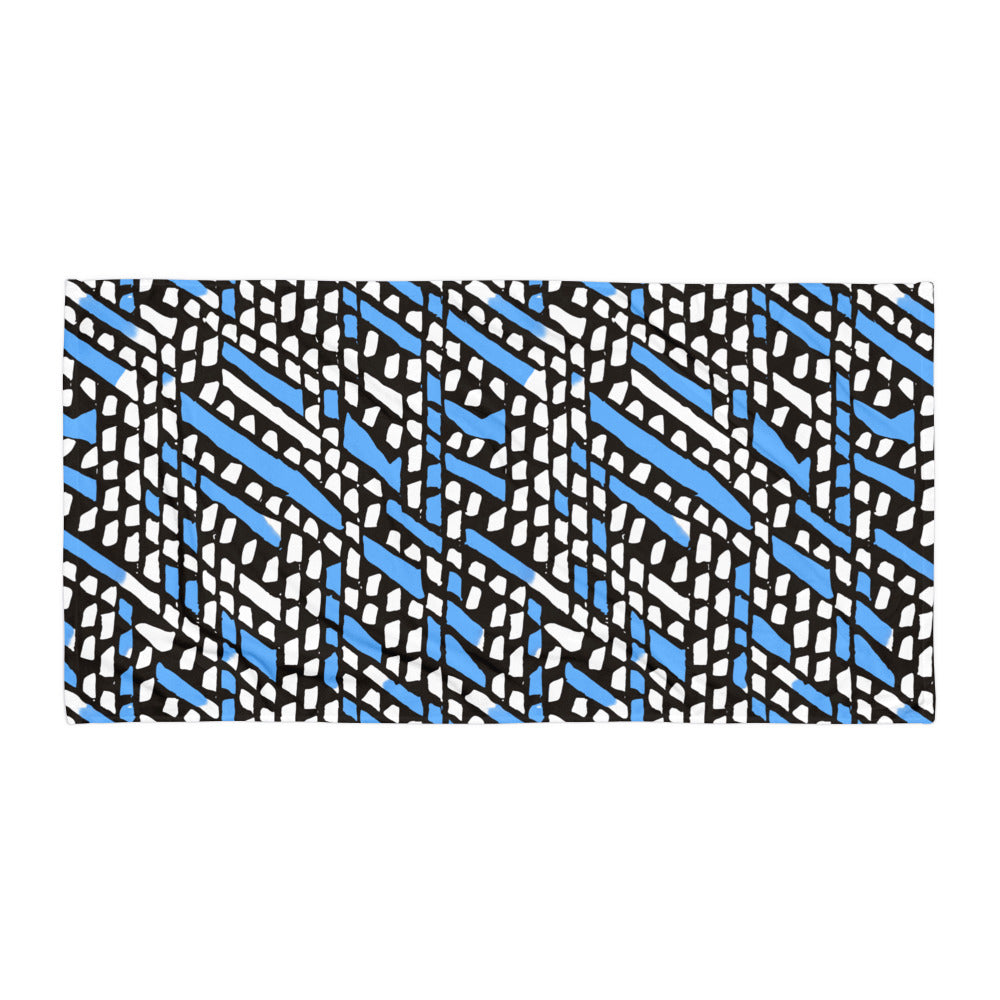 Blue Ilorin beach towel from Tintin Studios spread flat on a white background, featuring its earthy, nature-inspired patterns.