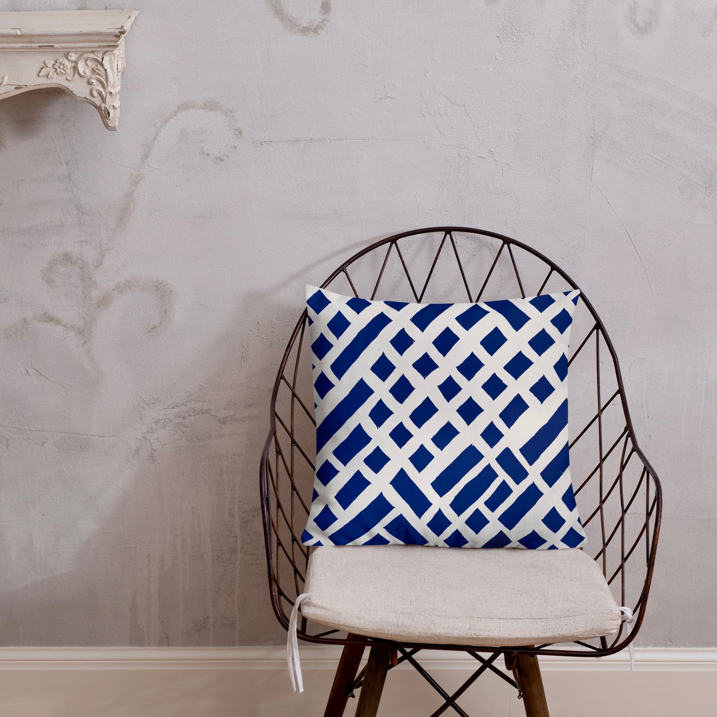 18x18 Felele blue throw pillow from Tintin Studios, rich in cultural patterns on a black iron chair.