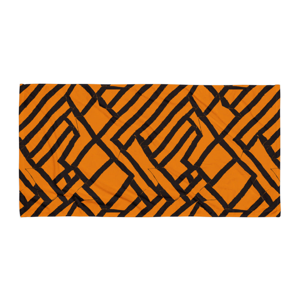 Vibrant orange Lokoja beach towel from Tintin Studios, spread flat on a white background, emphasizing its bold geometric design and visual appeal.