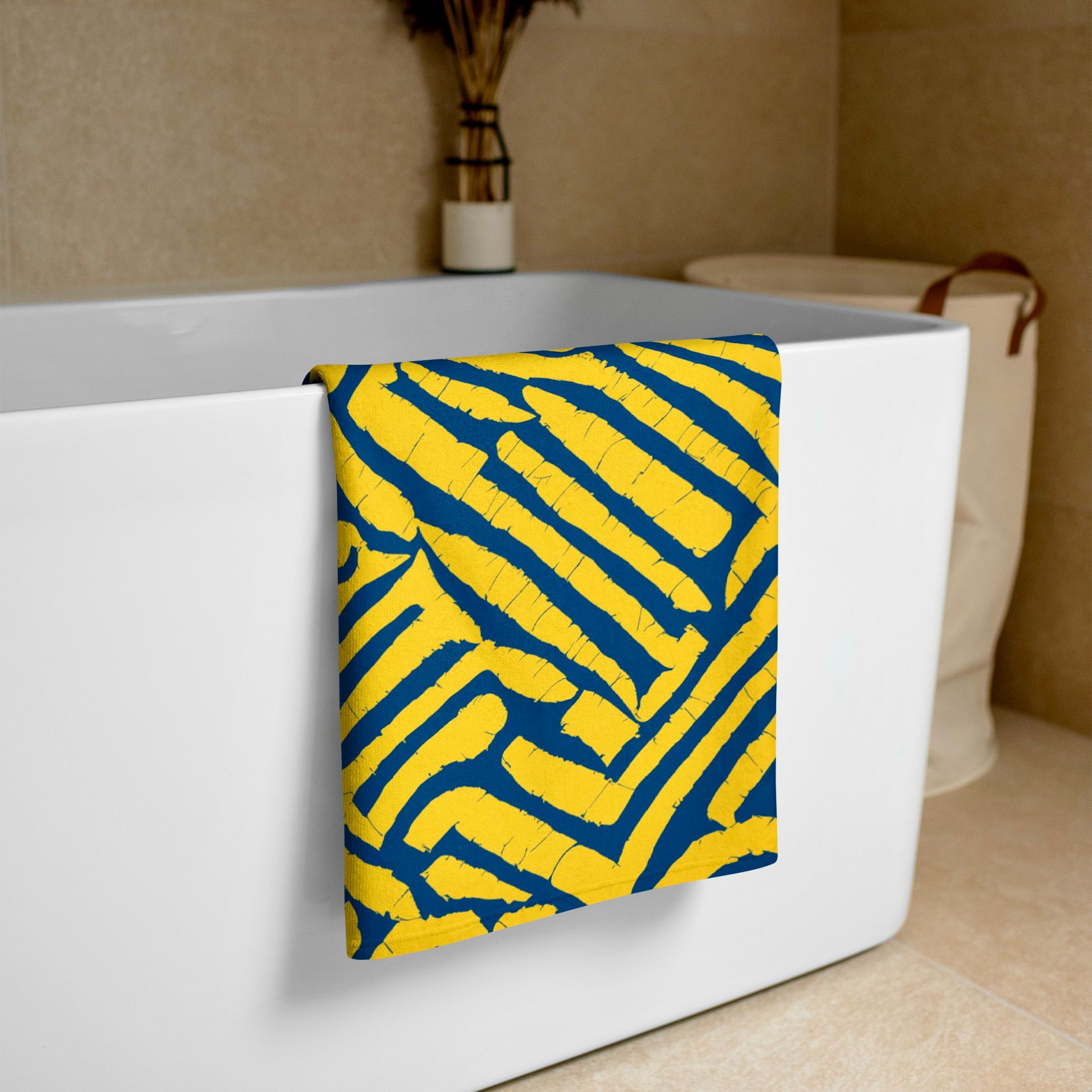 Blue ChiChi beach towel from Tintin Studios, draped over a white bathtub, featuring its colourful, artistic flair.