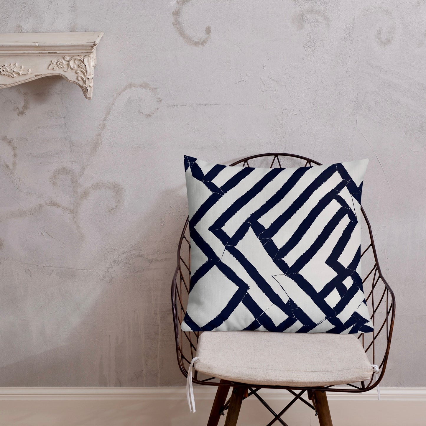 22x22 Lokoja blue throw pillow from Tintin Studios on a black iron chair, emphasising striking geometric visuals