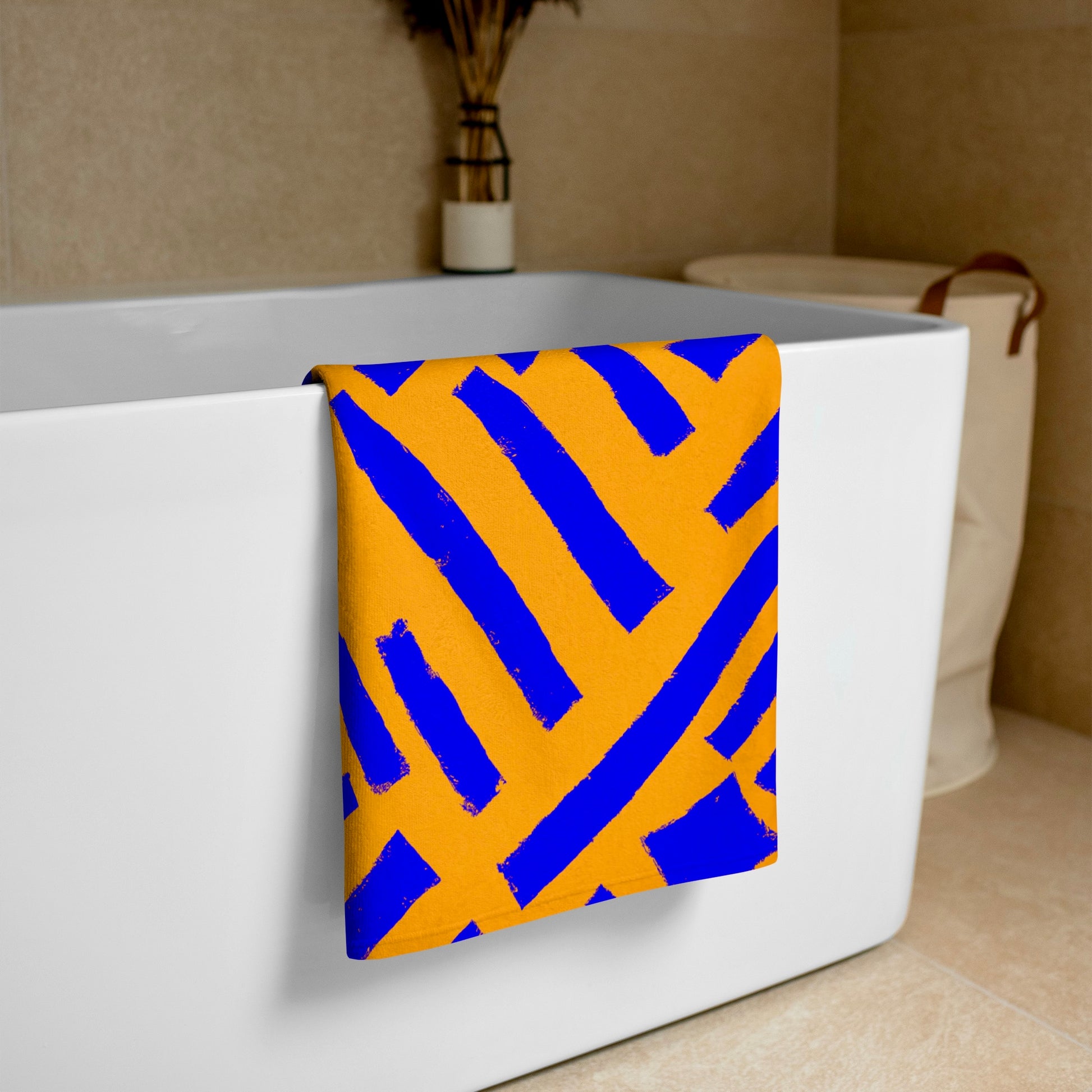 Blue Tutu beach towel from Tintin Studios draped over a white bathtub, combining functionality with artistic flair in its vibrant design.