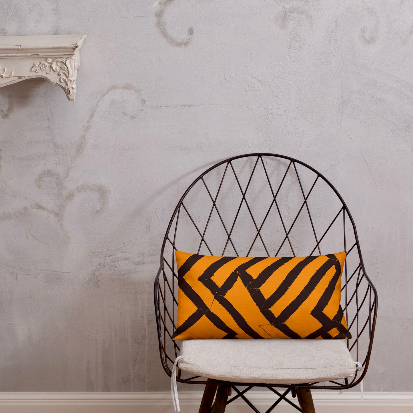 20x12 Lokoja orange throw pillow from Tintin Studios, showcasing vibrant patterns on a black iron chair.