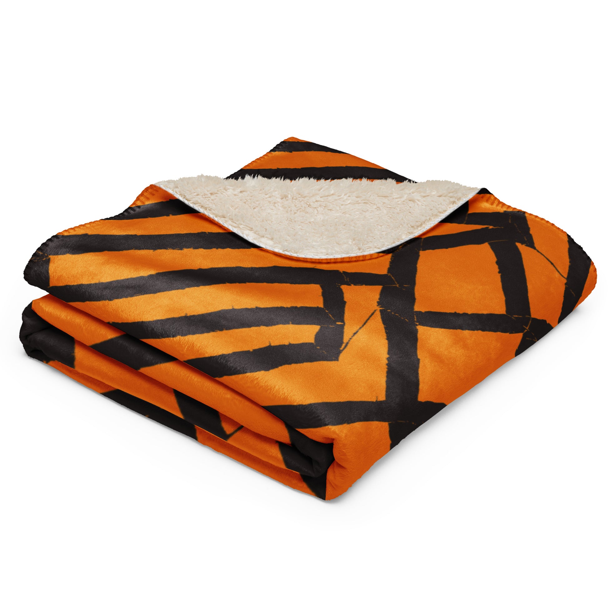 Tintin Studios' orange folded Lokoja Sherpa blanket showcasing sharp geometric patterns against its soft sherpa texture, reflecting a perfect blend of modern design and cozy warmth.